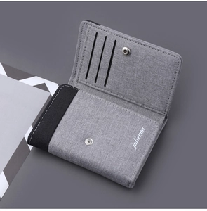 Close-up of canvas tri-fold wallet featuring three card slots and metal snap closure