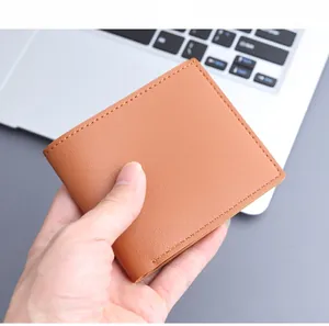Close-up of tan leather wallet with reinforced edge stitching and fine grainy texture