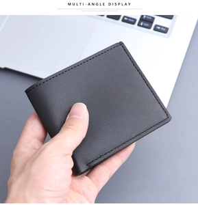 Close-up of a black lychee texture bifold leather wallet for men held by hand