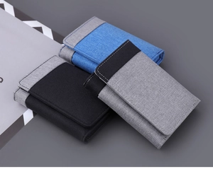 Detailed view of tri-fold canvas wallets in navy, black and grey with contrast stitching