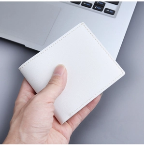 Close-up of minimalist white leather wallet with litchi texture and neat stitching details