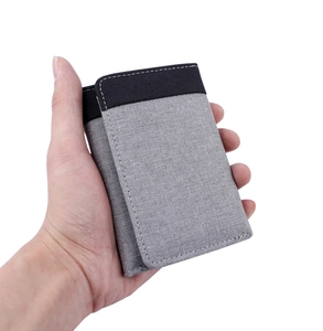 Close-up of men's tri-fold canvas wallet with contrast grey and black fabric texture
