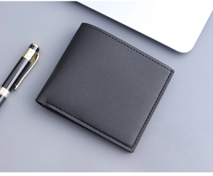 Close-up of a minimalist black lychee grain leather bifold wallet with neat stitching detail
