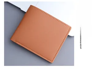 Close-up of brown bifold men's wallet showing lychee texture and precise stitching