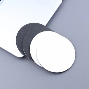Macro shot showing white and black leather car coasters with a refined anti-slip texture