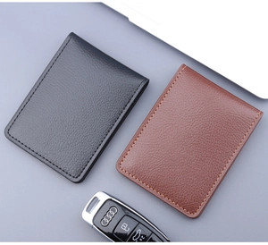 Porte-cartes fins en cuir noir et marron avec coutures précises près d'une clé