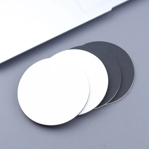 Close-up of circular faux leather car coasters in white and black with lychee texture