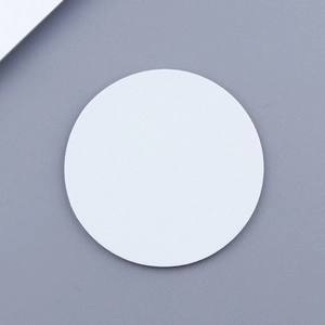 Macro detail of white round car coaster showing matte leather texture and clean edges
