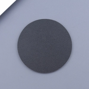 Macro detail of black leather car coaster with premium litchi grain texture surface