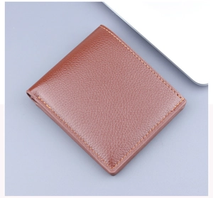 Close-up of brown leather bifold wallet with orange stitching and lychee grain texture