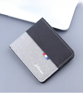 Close-up of gray and black canvas bifold wallet with contrast stitching and woven texture