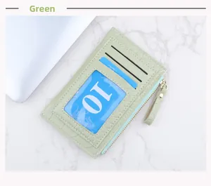 Détail d'un porte-cartes vert à motif crocodile avec trois fentes et zip doré élégant