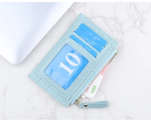 Gros plan du porte-cartes bleu clair à texture crocodile avec fente zippée durable