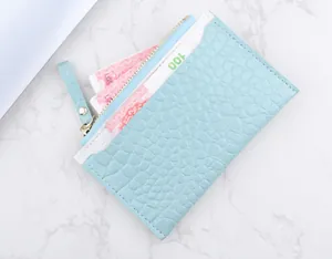 Détail du portefeuille texture crocodile bleu clair avec fermeture éclair dorée