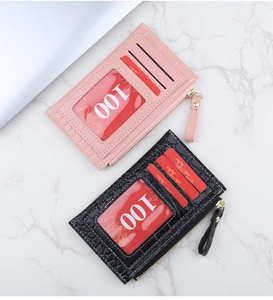 Détail de porte-cartes mince rose et noir motif crocodile avec pochette zippée pratique