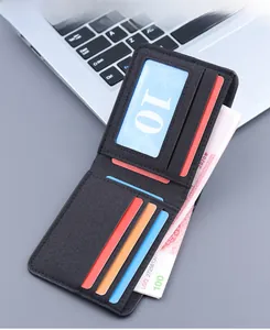Detail of slim black leather bi-fold wallet with five card slots and ID window on a laptop