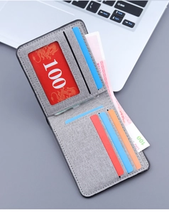 Close-up of slim gray fabric wallet featuring multiple card slots and clear ID window