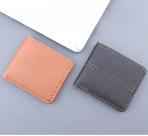Close-up of minimalist bifold wallets in tan and dark gray with lychee leather texture