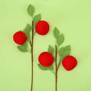 Handmade crochet fruit bouquet with red berries on green background for home decoration