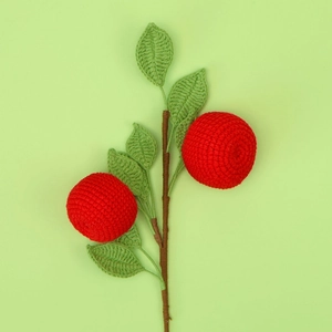 Handmade crochet persimmon fruit branch with red knitted fruit and green leaves