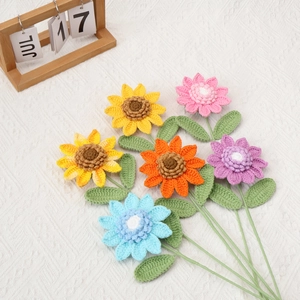 Handmade crochet sunflower and daisy flower bouquet set on elegant white textured fabric
