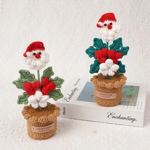 Handmade crochet Santa Claus potted plants with red flowers for festive home decoration