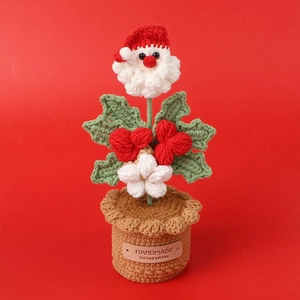 Macro shot of handmade crocheted Santa Claus potted plant decoration with knitted textures
