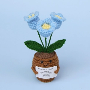 Macro detail of handmade crochet lily of the valley in pot with cute smiling face