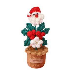 Handmade crochet Santa Claus potted plant decoration with festive red hat and green leaves
