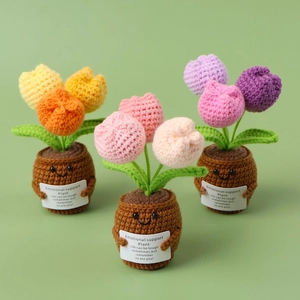 Detailed view of handmade crochet tulips with cute smiling faces and support cards