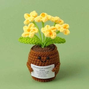 Macro view of handmade crochet sunflower plant with a smiling face and card