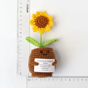 Handmade knitted sunflower in a pot with a scale ruler showing a height of about 17cm