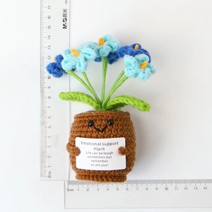 Macro view of handmade crochet potted flower with emotional support card and scale ruler