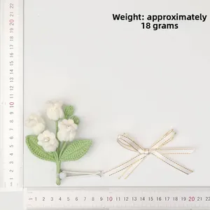 Detailed view of hand-knitted lily of the valley clip with weight at 18 grams