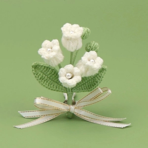 Handmade crochet white flower hairpin with green leaves and ribbon bow on green background