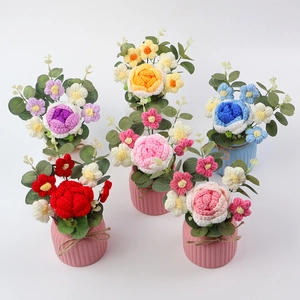 Detailed overhead view of various colorful handmade crochet rose flower potted plants