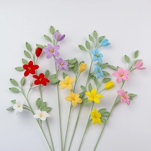 Detail von handgefertigtem Häkel-Sternjasmin-Strauß mit grünen Blättern auf weißem Grund