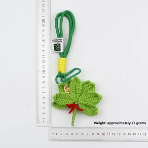 Detail of handmade green pomelo leaf crochet charm with lucky charm and ruler scale