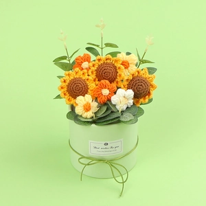 Handgefertigter gestrickter Sonnenblumenstrauß im grünen Topf für die Tischdeko