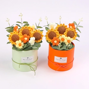 Makroaufnahme handgefertigter Häkel-Sonnenblumen in Töpfen mit bunten Strickstrukturen