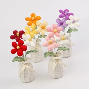 Detail of handmade crochet plumeria bouquets in white pots with golden bows