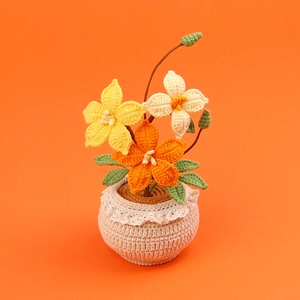 Détail d'une plante de clématite faite main au crochet avec fleurs jaunes et oranges