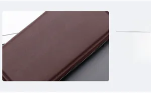 Close-up of brown litchi pattern leather showing fine stitching and metal zipper detail