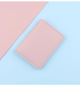 Close-up of pink leather card holder showing premium stitching and slim folding design