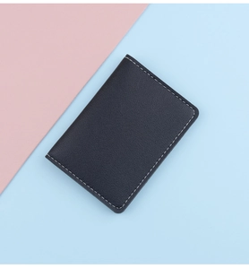Close-up of black lychee leather card holder with white double stitching and slim design