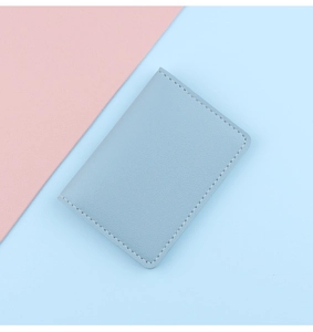 Detail of light blue leather card holder with fine white stitching and pebble texture