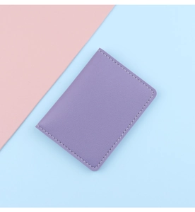 Detail of purple faux leather card holder showing lychee texture and stitching