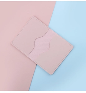 Close-up of pink slim leather card holder with two curved slots and neat stitching