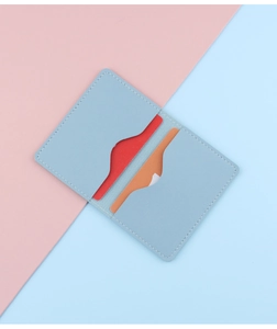 Close-up of light blue leather card holder with two slots and lychee pattern texture