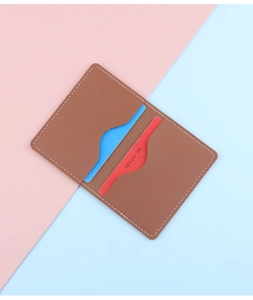 Detailed view of brown lychee grain leather card holder with two slots and white stitching